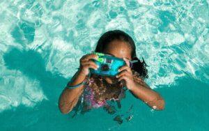 kids with waterproof camera in sea
